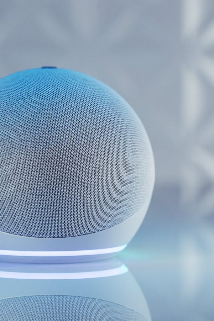 pexels-photo-14309812-14309812 A sleek smart speaker with neon glow on reflective surface, showcasing modern technology.